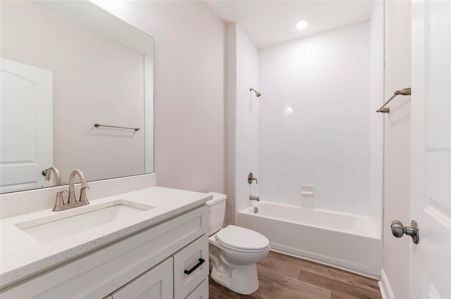 bathroom with toilet,  shower combination, recessed lighting, vanity, and wood finished floors