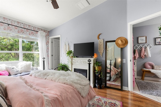 2125 Wild Grape Pl, Riverview, FL 33578 - bedroom featuring vaulted ceiling, wood finished floors, a glass covered fireplace, and ceiling fan