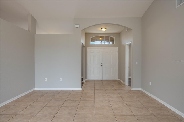 entrance foyer with visible vents, arched walkways, and light tile patterned floors