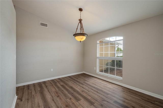 empty room with visible vents, baseboards, and wood finished floors
