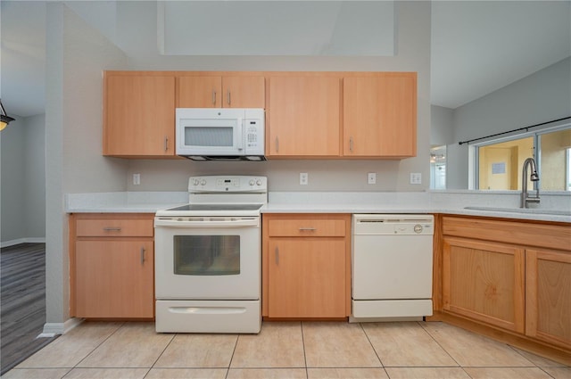 kitchen with white appliances, light tile patterned flooring, light countertops, a sink, and light brown cabinets