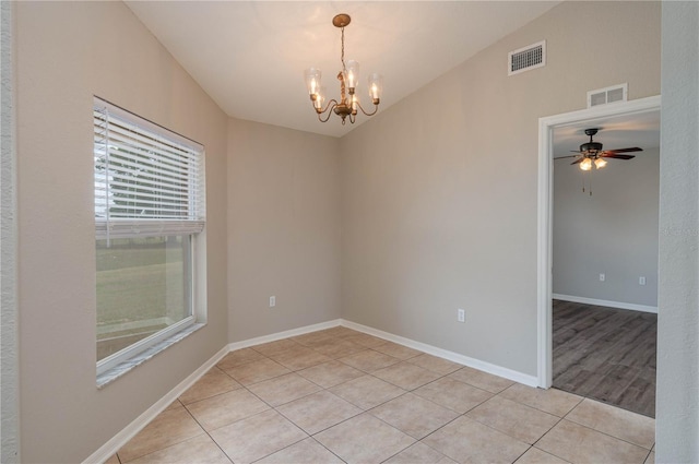 unfurnished room with visible vents, baseboards, light tile patterned floors, and ceiling fan with notable chandelier