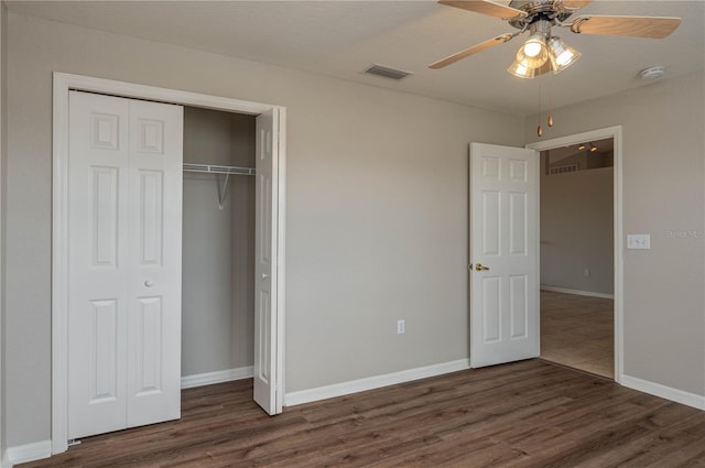 unfurnished bedroom featuring visible vents, a closet, baseboards, and wood finished floors