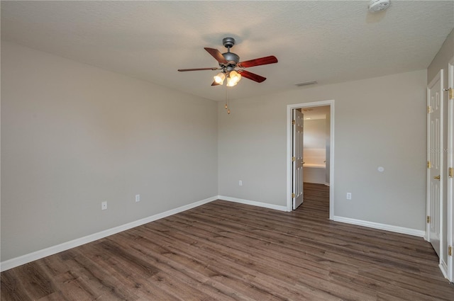 unfurnished bedroom with dark wood-style flooring, visible vents, baseboards, and ceiling fan
