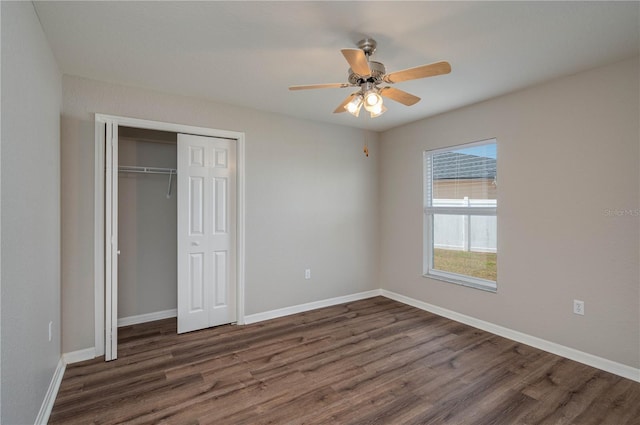 unfurnished bedroom featuring a closet, ceiling fan, baseboards, and dark wood finished floors