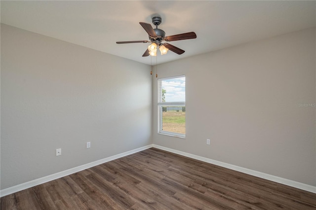 spare room featuring dark wood-type flooring, baseboards, and ceiling fan