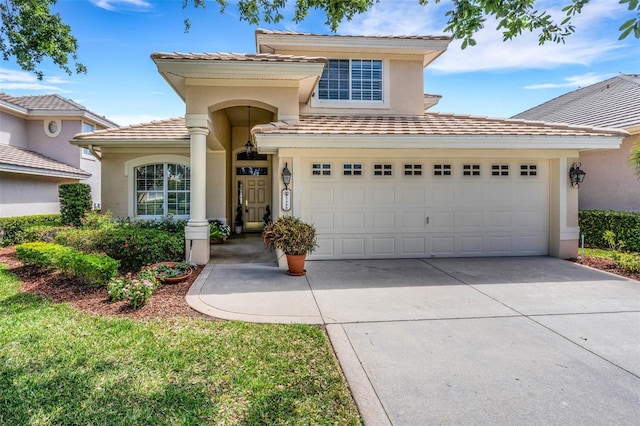 view of front of home featuring stucco siding, a tile roof, an attached garage, and concrete driveway