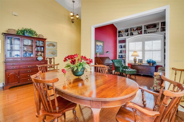 dining area with light wood-type flooring and built in shelves