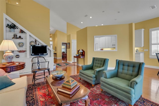 living room featuring recessed lighting, light wood-type flooring, visible vents, and baseboards