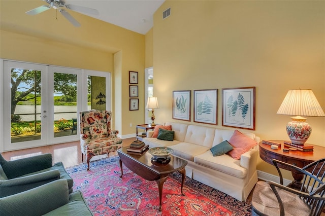 living area featuring french doors, baseboards, visible vents, a ceiling fan, and high vaulted ceiling