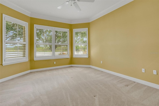 spare room featuring light colored carpet, baseboards, a ceiling fan, and a healthy amount of sunlight