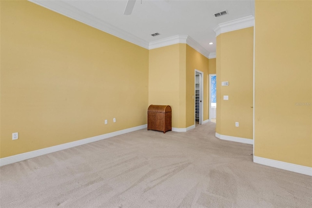 carpeted empty room featuring visible vents, crown molding, baseboards, and a ceiling fan
