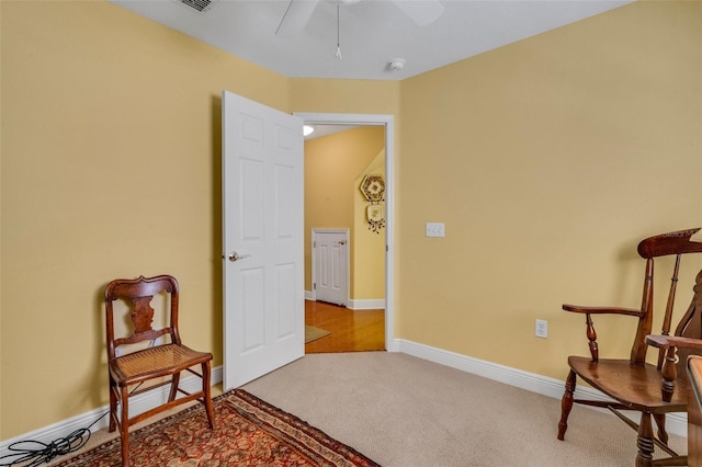 sitting room with ceiling fan, carpet floors, visible vents, and baseboards
