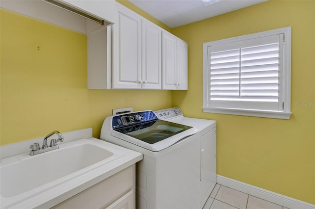 laundry area featuring a sink, light tile patterned flooring, independent washer and dryer, baseboards, and cabinet space