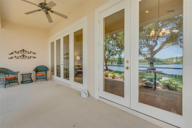 unfurnished sunroom with carpet flooring, a notable chandelier, french doors, and a water view