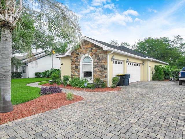 3300 Hawks Ridge Dr, Lakeland, FL 33810 - view of front of house featuring stone siding, decorative driveway, a garage, stucco siding, and a front lawn
