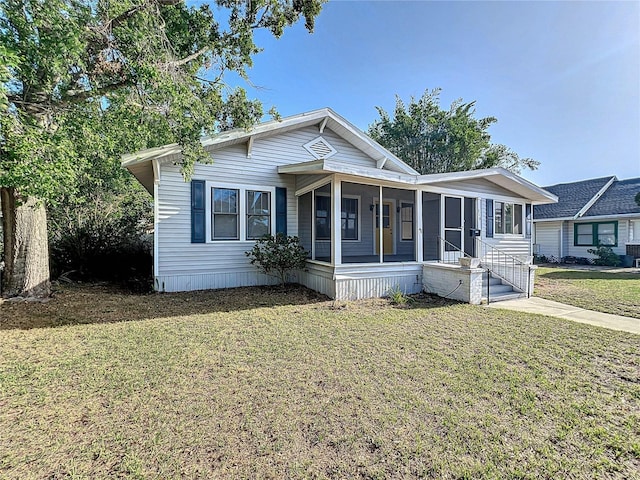 view of front facade with a front lawn and a sunroom