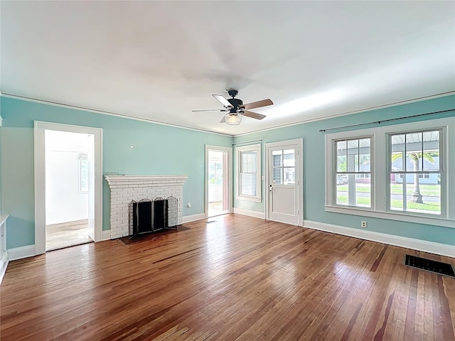 unfurnished living room with hardwood / wood-style floors, ceiling fan, baseboards, and ornamental molding
