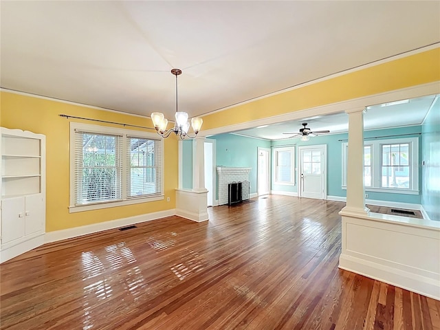 unfurnished living room with ornamental molding, a wealth of natural light, decorative columns, and hardwood / wood-style flooring