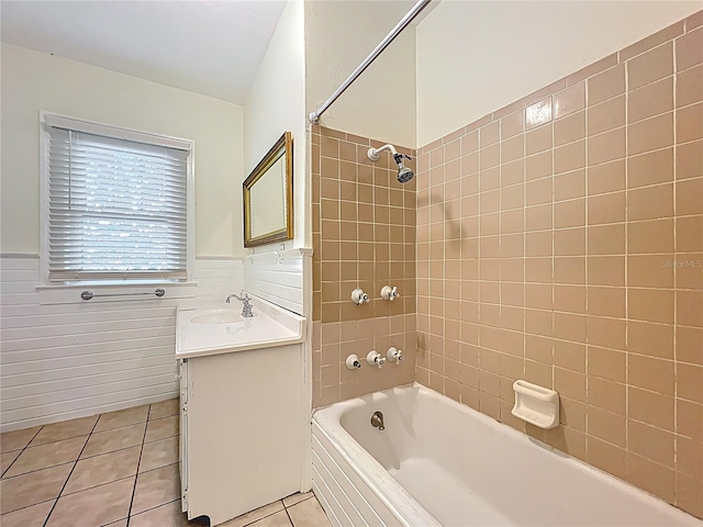 full bath with tile patterned flooring, vanity, a wainscoted wall, and shower / washtub combination