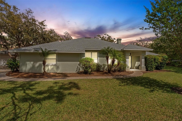 12301 Jim Edwards Rd, Haines City, FL 33844 - view of front of property featuring a yard, a chimney, stucco siding, and roof with shingles