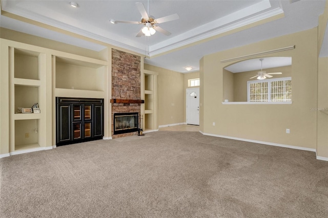 12301 Jim Edwards Rd, Haines City, FL 33844 - unfurnished living room featuring ceiling fan, built in features, carpet floors, a stone fireplace, and a raised ceiling