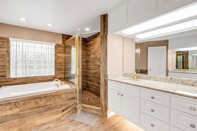 12301 Jim Edwards Rd, Haines City, FL 33844 - bathroom with a stall shower, a bath, vanity, wood finished floors, and recessed lighting