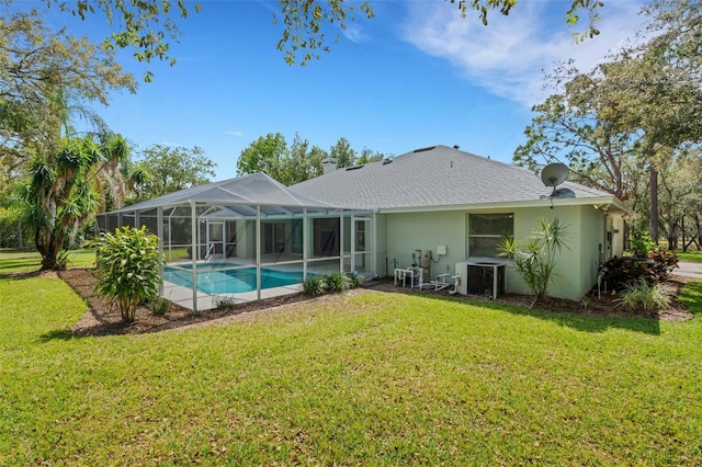 12301 Jim Edwards Rd, Haines City, FL 33844 - rear view of property featuring a lawn, stucco siding, an outdoor pool, and central AC unit