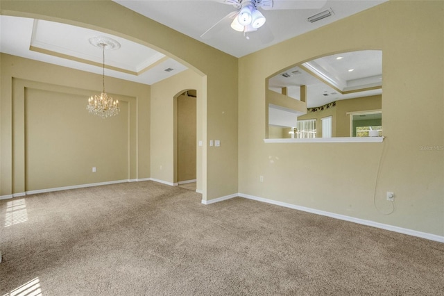 12301 Jim Edwards Rd, Haines City, FL 33844 - carpeted empty room with a raised ceiling, arched walkways, ceiling fan, and a chandelier