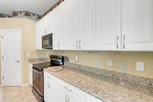 12301 Jim Edwards Rd, Haines City, FL 33844 - kitchen with black microwave, electric stove, and white cabinetry