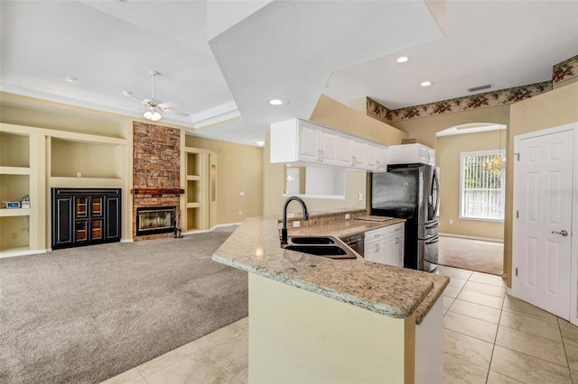 12301 Jim Edwards Rd, Haines City, FL 33844 - kitchen featuring a sink, light carpet, stainless steel appliances, ceiling fan, and light stone counters