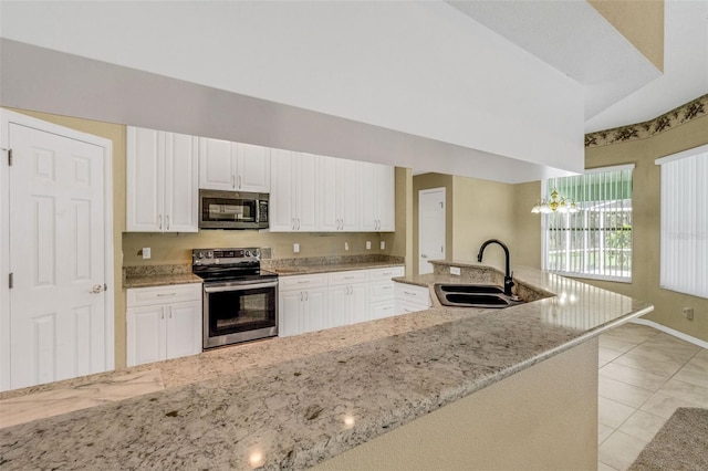 12301 Jim Edwards Rd, Haines City, FL 33844 - kitchen featuring appliances with stainless steel finishes, a sink, white cabinetry, and light stone countertops