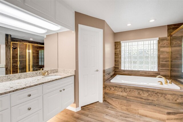 12301 Jim Edwards Rd, Haines City, FL 33844 - full bathroom with a shower stall, vanity, a bath, wood finished floors, and recessed lighting
