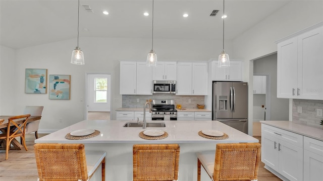 505 Shanklin Ave, Bartow, FL 33830 - kitchen featuring appliances with stainless steel finishes, backsplash, light countertops, a breakfast bar area, and lofted ceiling