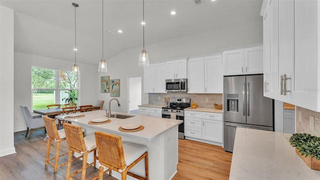 505 Shanklin Ave, Bartow, FL 33830 - kitchen featuring appliances with stainless steel finishes, tasteful backsplash, light wood-type flooring, a kitchen bar, and recessed lighting