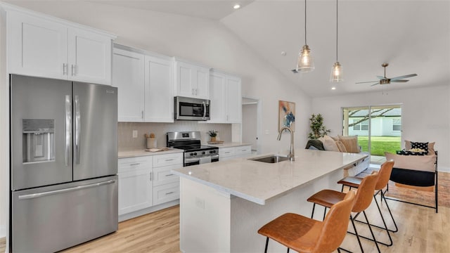 803 Allison Pl, Bartow, FL 33830 - kitchen with appliances with stainless steel finishes, vaulted ceiling, light wood-style flooring, open floor plan, and white cabinetry