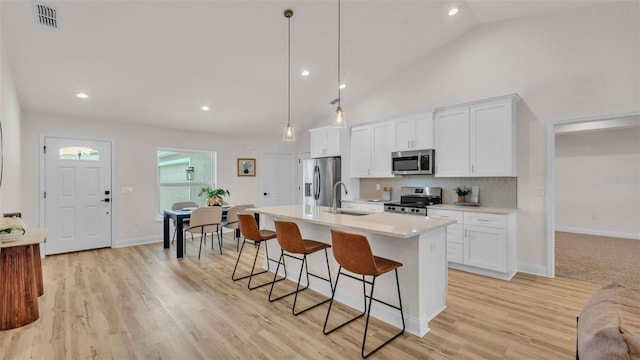 803 Allison Pl, Bartow, FL 33830 - kitchen featuring stainless steel appliances, a kitchen bar, a center island with sink, white cabinets, and light countertops