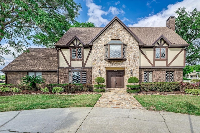 3906 Canyon Lake Pt, Lakeland, FL 33813 - tudor home with roof with shingles, stucco siding, and brick siding