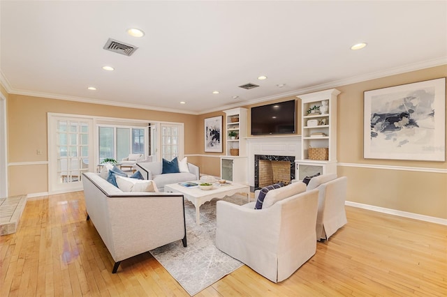 3906 Canyon Lake Pt, Lakeland, FL 33813 - living area with a high end fireplace, crown molding, light wood-style flooring, and visible vents