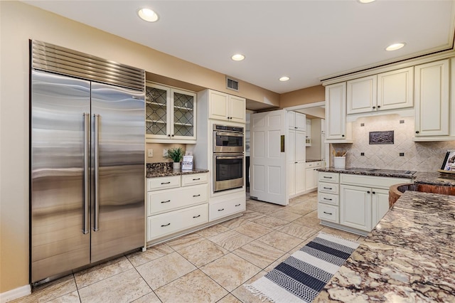 3906 Canyon Lake Pt, Lakeland, FL 33813 - kitchen featuring dark stone counters, visible vents, backsplash, appliances with stainless steel finishes, and recessed lighting