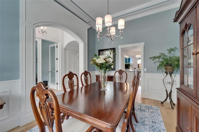 9004 Selph Rd, Lakeland, FL 33810 - dining room with a chandelier, arched walkways, ornamental molding, and a wainscoted wall