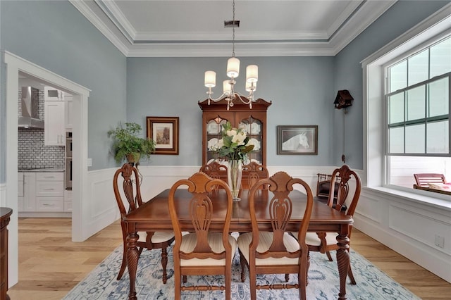 9004 Selph Rd, Lakeland, FL 33810 - dining area featuring light wood-style flooring, plenty of natural light, an inviting chandelier, and a wainscoted wall