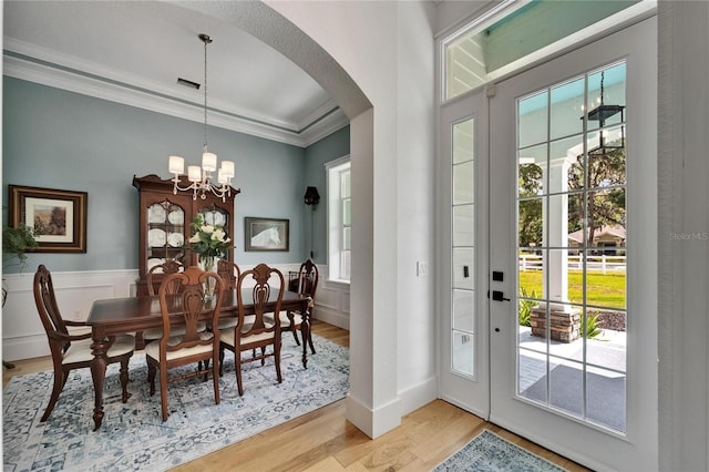9004 Selph Rd, Lakeland, FL 33810 - dining area with light wood-style flooring, arched walkways, a healthy amount of sunlight, and crown molding