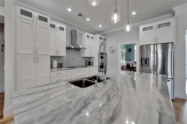 9004 Selph Rd, Lakeland, FL 33810 - kitchen with visible vents, ornamental molding, wall chimney range hood, appliances with stainless steel finishes, and white cabinetry