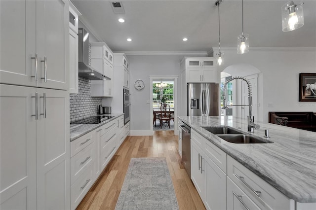 9004 Selph Rd, Lakeland, FL 33810 - kitchen with crown molding, wall chimney exhaust hood, appliances with stainless steel finishes, arched walkways, and a sink