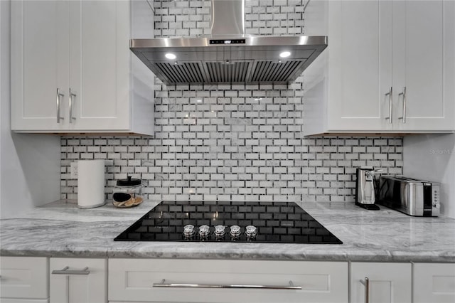 9004 Selph Rd, Lakeland, FL 33810 - kitchen with black electric stovetop, backsplash, ventilation hood, and white cabinets