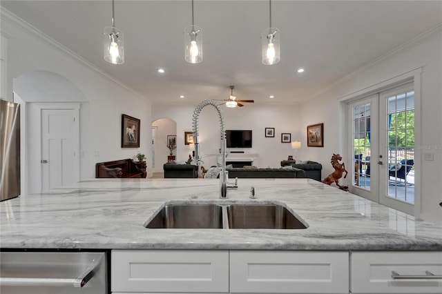 9004 Selph Rd, Lakeland, FL 33810 - kitchen with arched walkways, open floor plan, a ceiling fan, light stone countertops, and french doors
