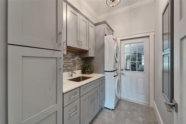 9004 Selph Rd, Lakeland, FL 33810 - washroom with baseboards, a sink, ornamental molding, stacked washing maching and dryer, and cabinet space