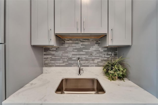 9004 Selph Rd, Lakeland, FL 33810 - kitchen with a sink, decorative backsplash, white cabinetry, and light stone counters