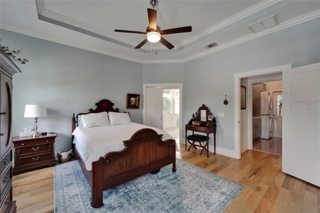 9004 Selph Rd, Lakeland, FL 33810 - bedroom with ensuite bathroom, a raised ceiling, white refrigerator, ornamental molding, and light wood finished floors
